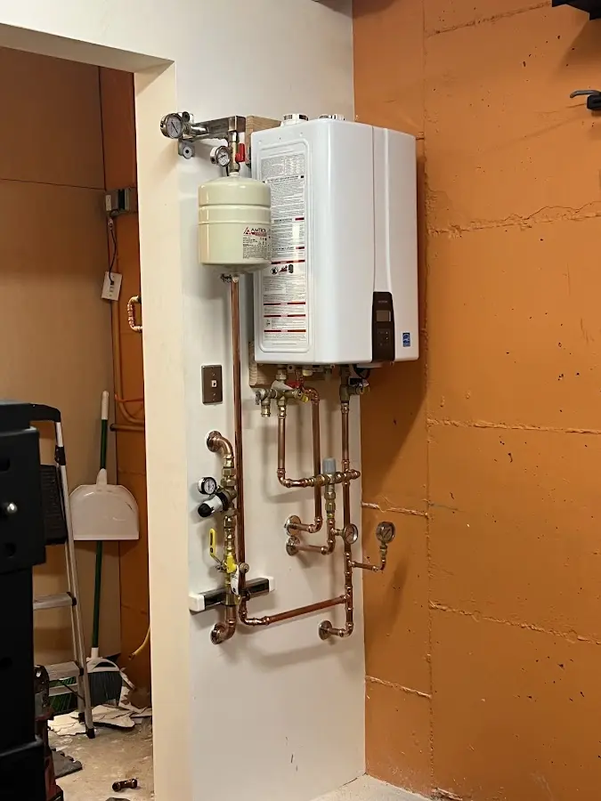 Plumbing technician inspecting water heater connections in Gold River